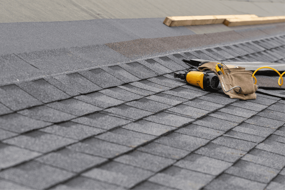 Roofing tools on gray shingle roof